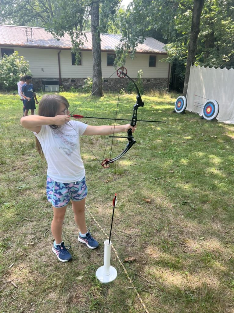 Child drawing a bow at the archery range