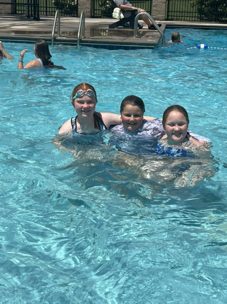 3 students swimming in the pool
