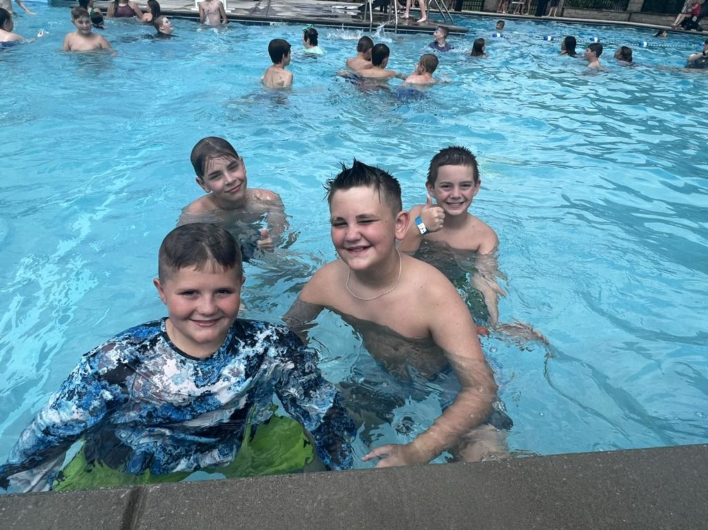4 students swimming in the pool