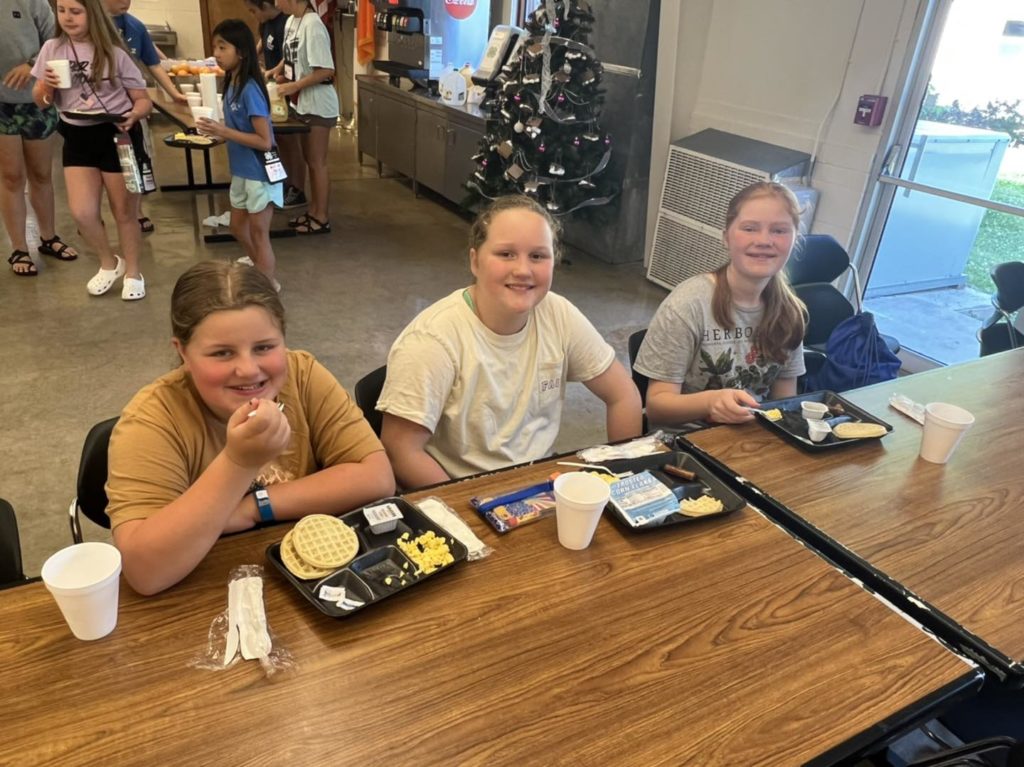 3 girls enjoying a meal in the 4-H cafeteria